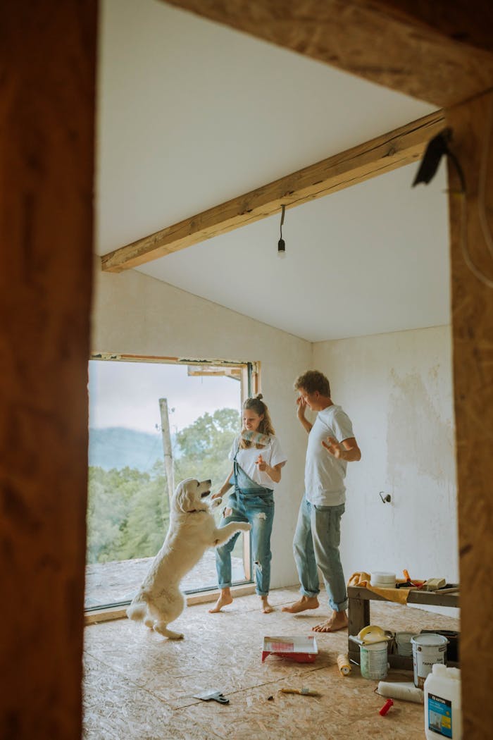 why-choose-us-03 Happy couple and dog renovating their home, enjoying a playful moment indoors.