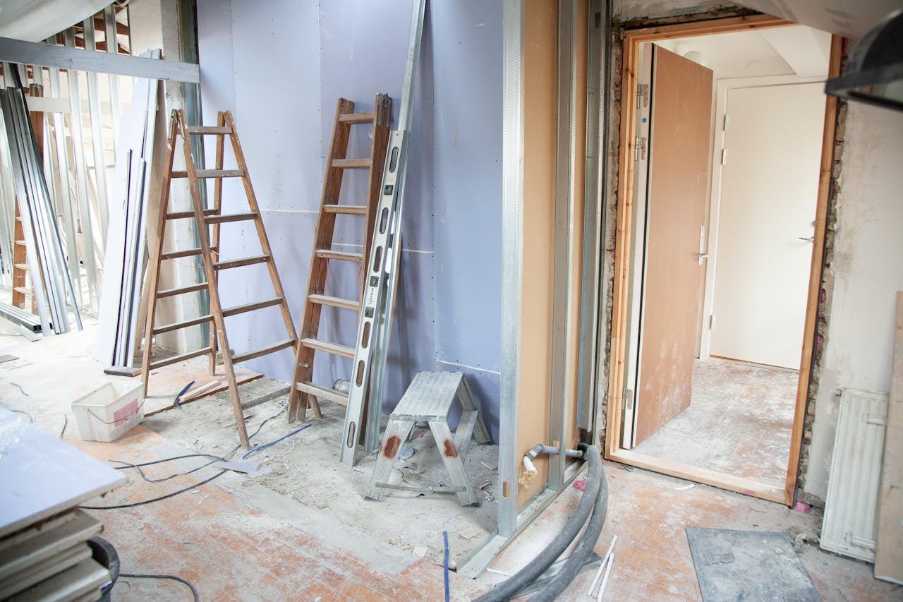 services-01 Construction site featuring ladders and tools in a home renovation setting.